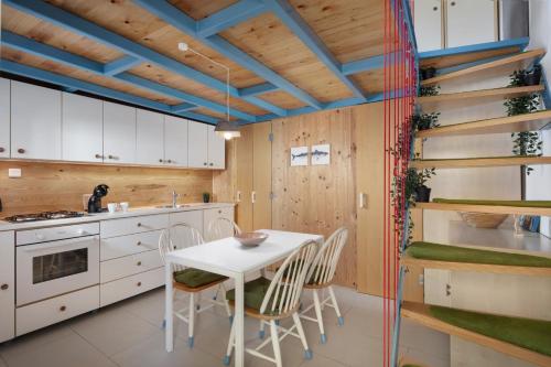 a kitchen with a table and chairs and wooden ceilings at Apartment Stone House Krk in Krk