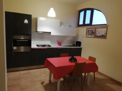 a kitchen with a table with a red table cloth at Mimì e Cocò Country House in Ascoli Piceno