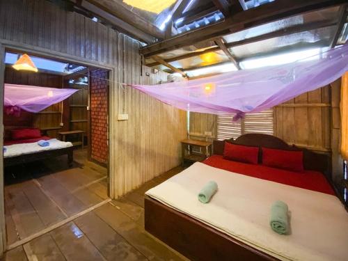 a bedroom with a bed and a mosquito net at Backpacker Hostel and Jungle Trekking in Banlung