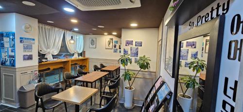een restaurant met tafels, stoelen en planten bij Ekonomy Hotel Incheon in Incheon