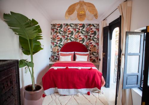 ein Schlafzimmer mit einem roten Bett mit einer roten Decke in der Unterkunft Cosy Riad in Marrakesch