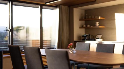 a dining room with a wooden table and chairs at Sengokubara COCON in Hakone