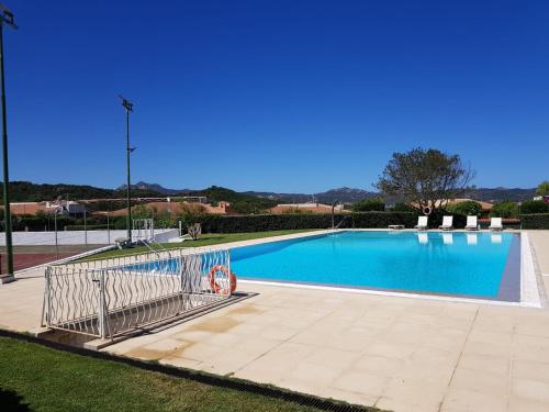 a large swimming pool in a park with a blue at Villa Alba in Cala Bitta