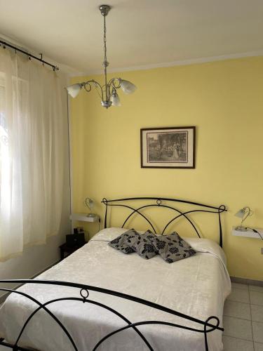 a bedroom with a bed and a chandelier at THE YELLOW HOUSE in Quartucciu
