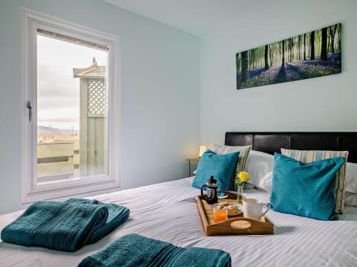 a bedroom with a bed with blue pillows and a window at 1 Bed in Aberdovey 91692 in Pennal