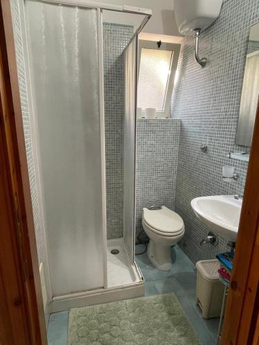 a bathroom with a shower and a toilet and a sink at THE YELLOW HOUSE in Quartucciu