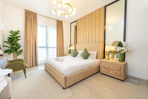 a bedroom with a large bed and a chandelier at FAM Living - Rahaal 1BR Bliss in Madinat Jumeirah Living in Dubai