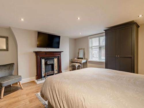 um quarto com uma cama, uma lareira e uma televisão em 4 Bed in Fleetwood 91701 em Fleetwood