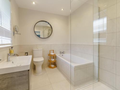 a bathroom with a tub and a toilet and a sink at 2 Bed in Gower 91725 