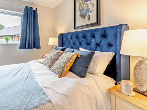 een blauw bed met kussens in een slaapkamer bij 2 Bed in Gower 91724 