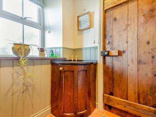 łazienka z drewnianą umywalką i oknem w obiekcie 4 Bed in Abersoch 91656 w mieście Bottwnog