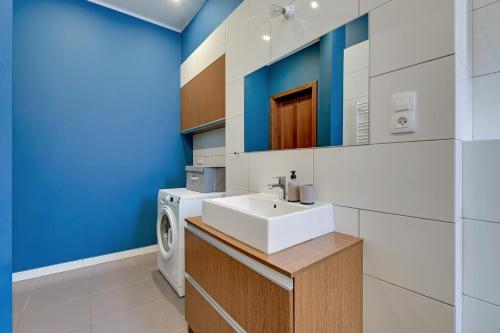 a bathroom with a sink and a washing machine at Downtown Apartments City Center Art House - Family Stay in Gdańsk