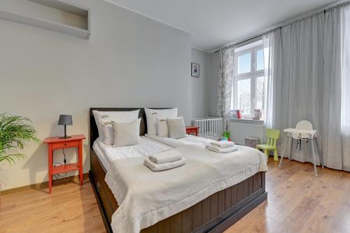 a bedroom with a large bed with towels on it at Downtown Apartments City Center Art House - Family Stay in Gdańsk