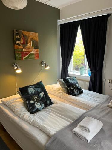 a bedroom with two beds and a window at Västerhöjdsgården in Skövde