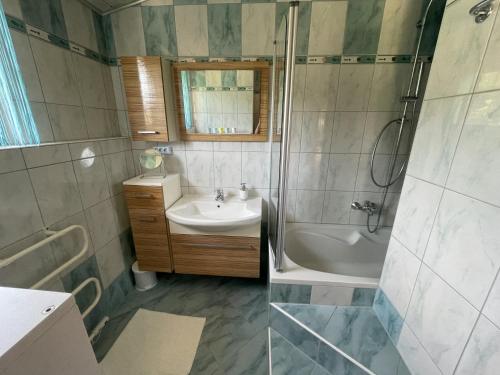 bagno con lavandino, doccia e vasca di Haus Linsendorf a Gallizien