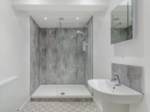 a white bathroom with a sink and a shower at 4 Bed in Westward Ho 91814 in Northam