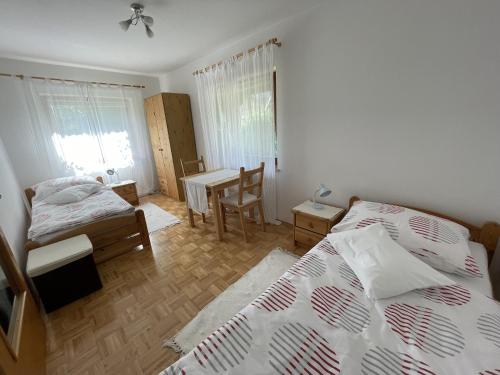 a bedroom with two beds and a table and a desk at Haus Linsendorf in Gallizien