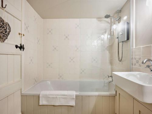 a white bathroom with a tub and a sink at 2 Bed in Hook Norton 92008 in Hook Norton