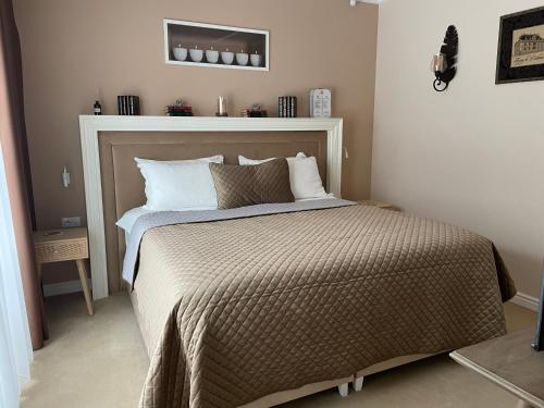 a bedroom with a large bed with a headboard at DoubleL Studios in Bacău
