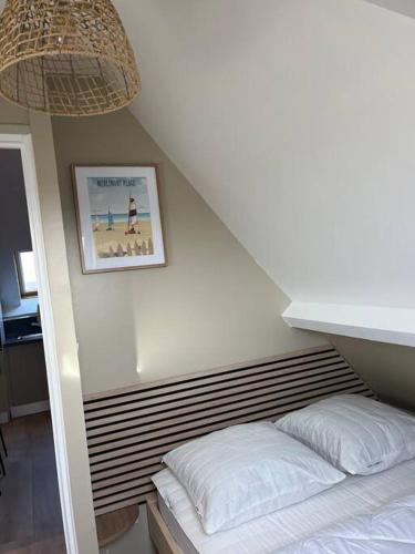 une chambre avec un lit et un tableau au mur dans l'établissement Appartement Merlimont Plage, à Merlimont