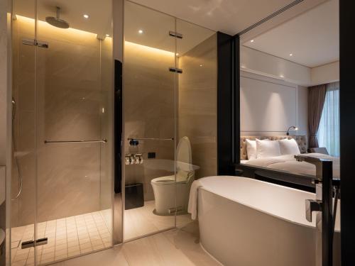 a bathroom with a shower and a tub and a toilet at Hotel Mvsa+Michelin 2 Starred Molino de Urdàniz in Taipei