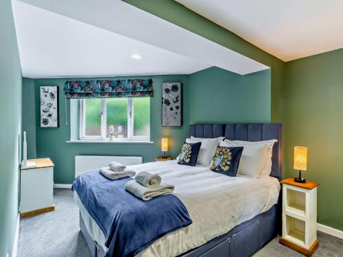 a bedroom with a large bed with blue walls at 3 Bed in Harrogate 92158 in Harrogate