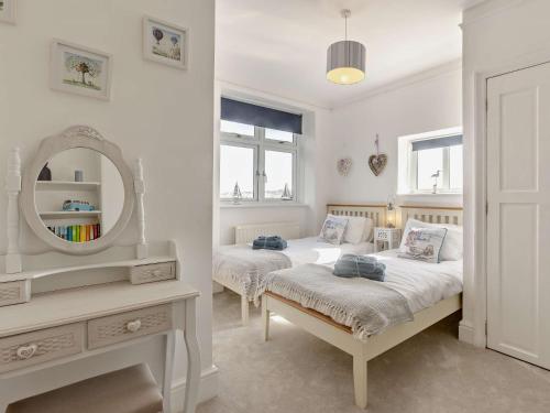 two beds in a white room with a mirror at 5 Bed in Westward Ho 91772 in Bideford