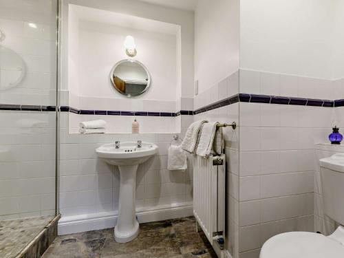 a bathroom with a sink and a toilet and a mirror at 1 Bed in Crewkerne 91795 in West Chinnock