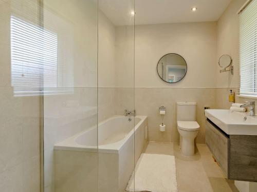 een badkamer met een bad, een toilet en een wastafel bij 2 Bed in Gower 91726 