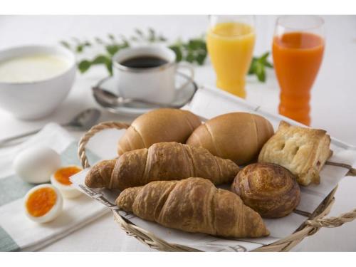 a plate of bread and croissants and eggs on a table at Shimonoseki Station West Washington Hotel Plaza in Shimonoseki
