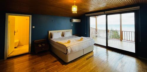 a bedroom with a bed with a view of the ocean at LİFOZ Holiday resort in Trabzon