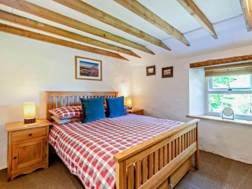 - une chambre avec un lit en bois et des oreillers bleus dans l'établissement 2 Bed in Glenridding 92087, à Glenridding