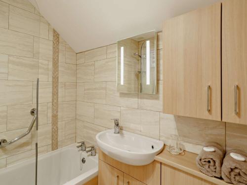 a white bathroom with a sink and a bath tub at 1 bed in Stamford Bridge 92093 in High Catton