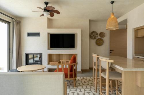 a living room with a table and chairs and a tv at Radisson Blu Hotel, Kas in Kas