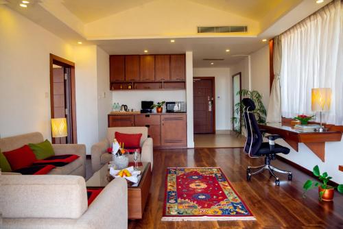 a living room with two couches and a kitchen at Mountain Glory Forest Resort in Pokhara