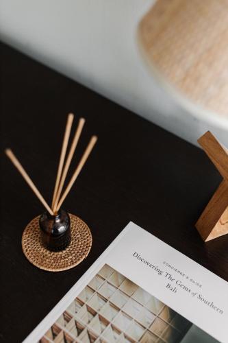 a table with a keyboard and a card and bamboo sticks at Kula Kara Villas Uluwatu in Uluwatu
