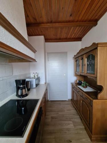 a kitchen with a black counter top and wooden cabinets at Gästewohnung KL. WZL 33_7 in Klein Wanzleben