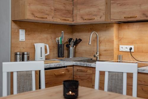 a kitchen with wooden cabinets and a table and chairs at Villa Sophia in Biskupiec