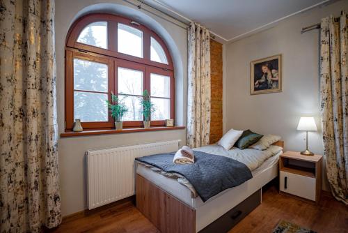 a bedroom with a bed and a large window at Villa Sophia in Biskupiec