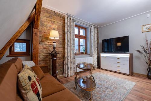 a living room with a couch and a tv at Villa Sophia in Biskupiec