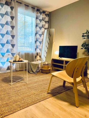 un salon avec une table et une télévision dans l'établissement L'Europe -Parking, Calme-, à Saint-Étienne