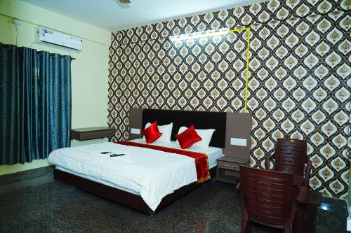 a bedroom with a bed with red pillows at LEE PARADISE INN in Bangalore