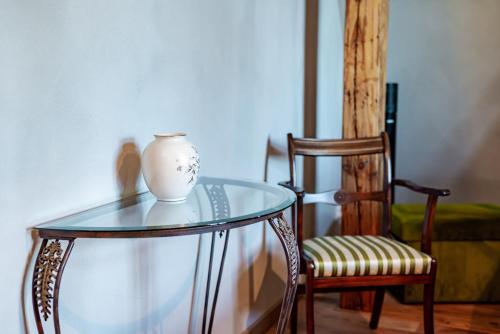 a glass table with a vase on it next to a chair at Villa Sophia in Biskupiec