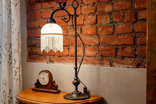 a lamp sitting on a table next to a clock at Villa Sophia in Biskupiec
