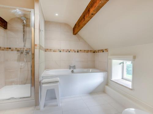 ein weißes Bad mit einer Badewanne und einer Dusche in der Unterkunft 1 Bed in Onecote 91864 in Onecote
