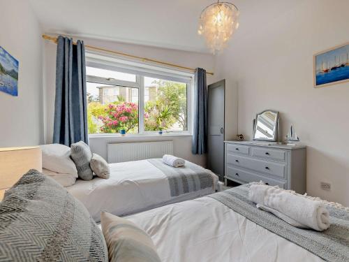 Un dormitorio con dos camas y una ventana. en 2 Bed in Aberdovey 91946, en Aberdyfi
