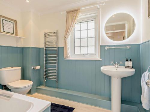 a blue bathroom with a sink and a toilet at 3 Bed in West Lulworth 92106 in West Lulworth