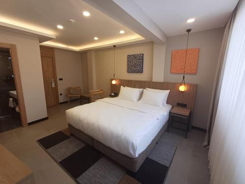 um quarto com uma grande cama branca e 2 almofadas em BeL LETTO HOTEL em Istambul