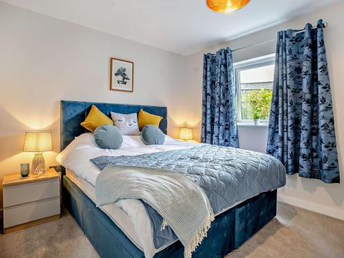 a bedroom with a blue bed with blue curtains at 3 Bed in Gower 91721 