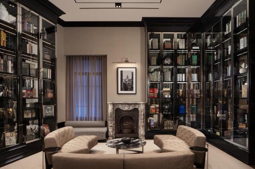 a library with a fireplace and chairs and a table at Sanasaryan Han, a Luxury Collection Hotel, Istanbul in Istanbul